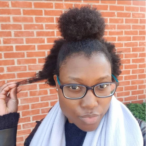 Woman with natural, coily hair wearing glasses